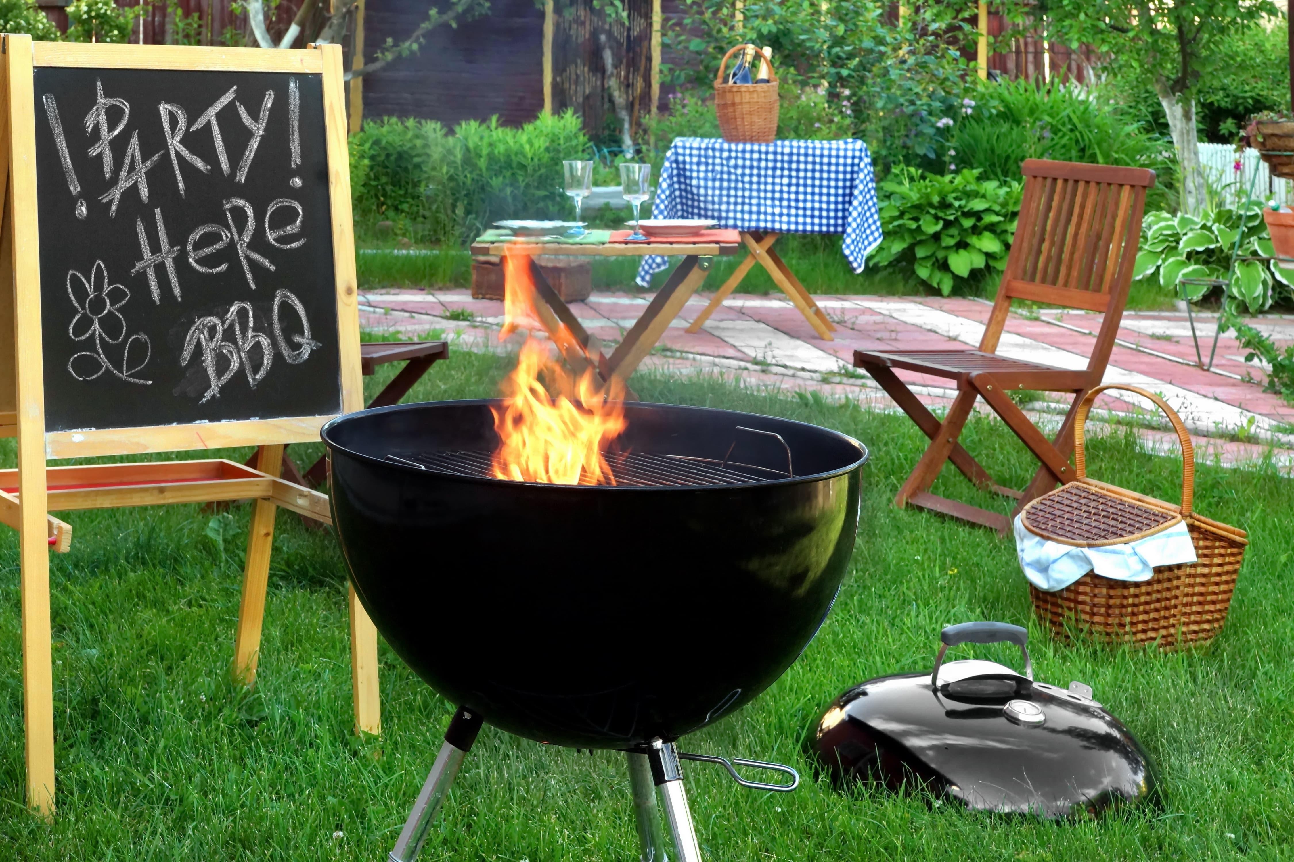 Charcoal grill and sign indicating a backyard BBQ party Charcoal grill and sign indicating a backyard BBQ party