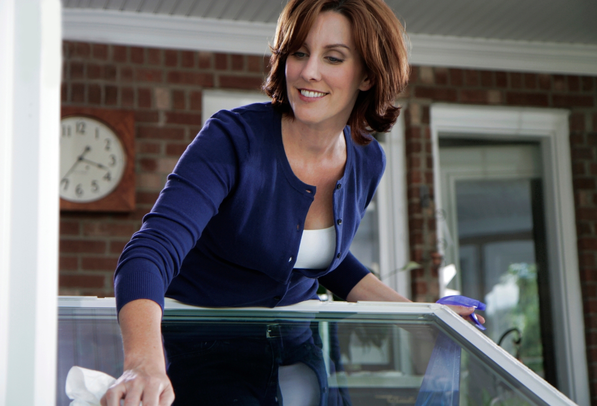 Woman testing out and cleaning her new windows Woman testing out and cleaning her new windows