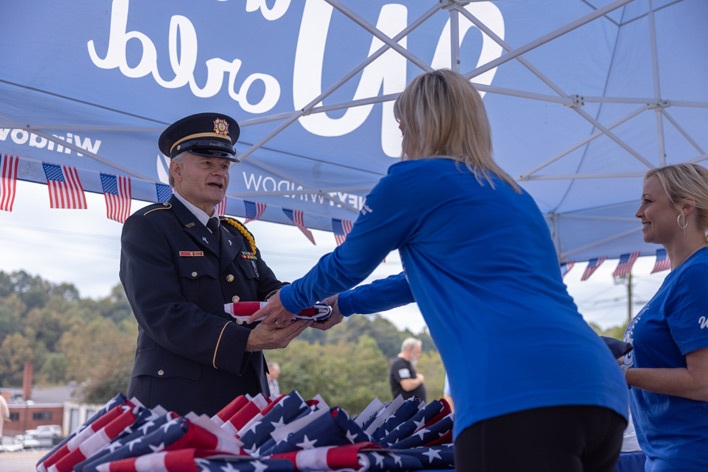 A member of the VFW exchanges an old American flag for a new one during Window World Old Glory Day A member of the VFW exchanges an old American flag for a new one during Window World Old Glory Day