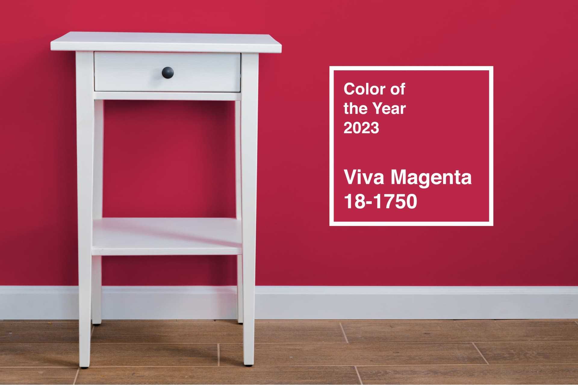 Pantone Color of the Year 2023, Viva Magenta, on an accent wall to contrast with a white table Pantone Color of the Year 2023, Viva Magenta, on an accent wall to contrast with a white table
