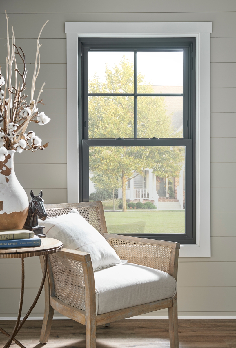 Black-framed double-hung window with traditional grid on top sash Black-framed double-hung window with traditional grid on top sash